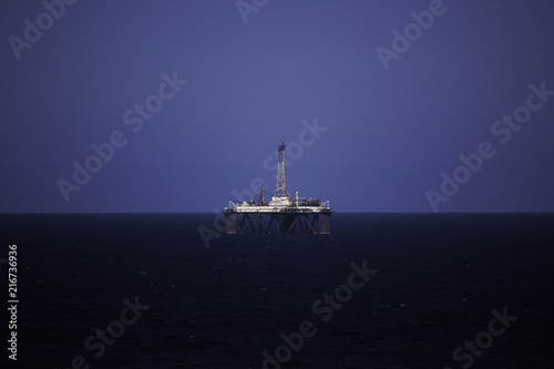 Oil Drilling Platform At Sea On Clear Blue Sky
