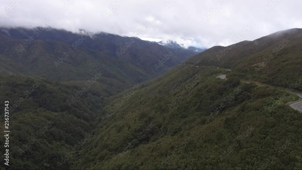 Stationary shot of mountains with some cars passing by on the right. Stationary shot of mountains with some cars passing by on the right.