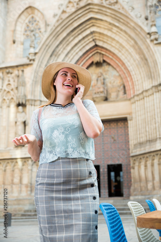 Young woman in hat talking on mobile phone at the street
