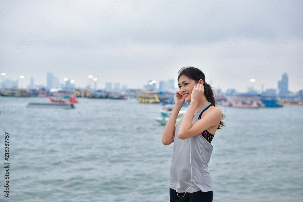 Sports concept. Beautiful girl is exercising on the beach with warm up. Beautiful girl is happy to exercise. Asian girls keep healthy with exercise. Sports concept. Beautiful girl is exercising on the beach with warm up. Beautiful girl is happy to exercise. Asian girls keep healthy with exercise.