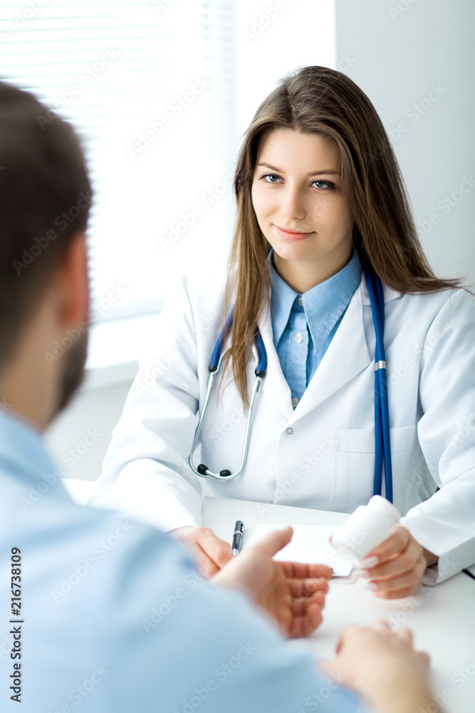 Doctor writes out the pills to the patient Doctor writes out the pills to the patient
