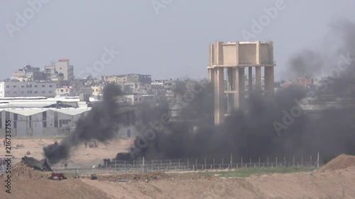 Palestinians from Gaza Strip burn tires near the Israeli border as they protest and demonstrate during last Friday of Ramadan. The smoke pollution meant to hurt Israeli snipers photo