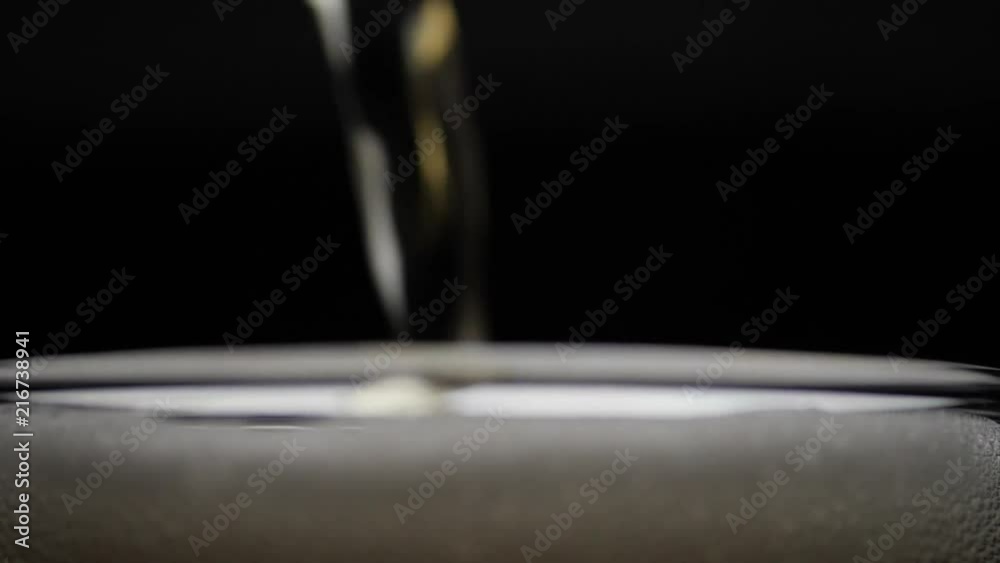 Beer is pouring into glass with foam sliding down side of beer glass Beer is pouring into glass with foam sliding down side of beer glass