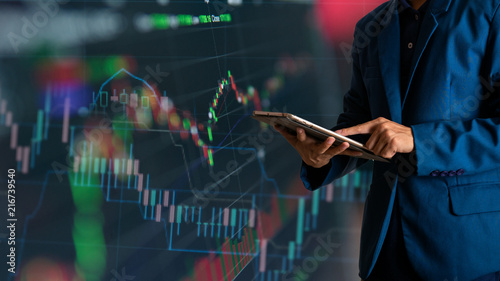 Tableau sur toile Businessman finger touching tablet with finance and banking profit graph of stoc