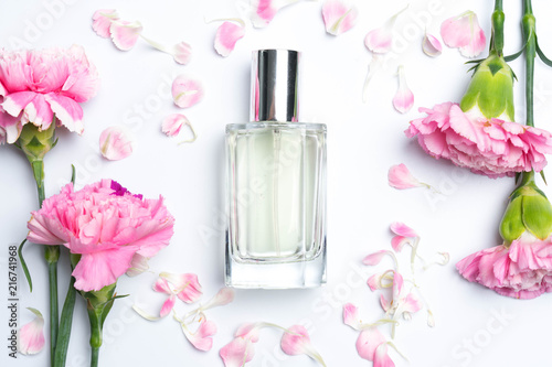 Perfume bottles and pink carnations on white background