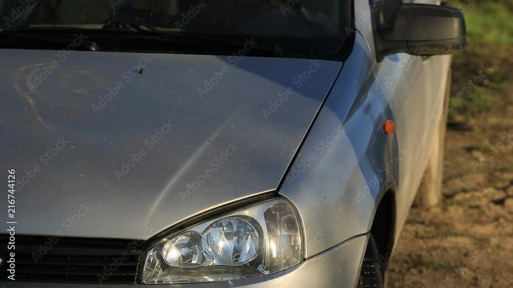 Young attractive man perfusing with water his silver car Young attractive man perfusing with water his silver car