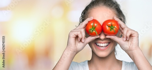 Beautiful laughing woman holding two ripe tomatoes © BillionPhotos.com