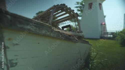 Beached lobster fishing boat near a lighthouse photo