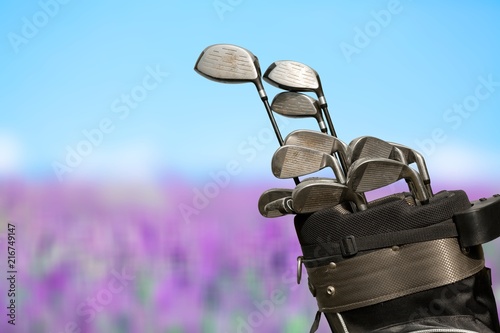 Different golf clubs on natural background