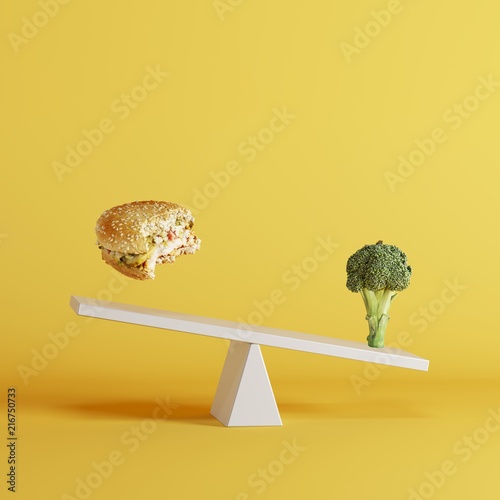 broccoli vegetable tipping seesaw with floating berger on opposite end on yellow background. food idea minimal.