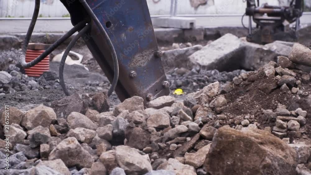 A big construction driller tearing up a street. Footage in slow motion. A big construction driller tearing up a street. Footage in slow motion.