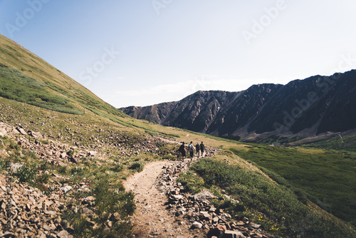 Four people walking on a trail in the mountains of Colorado. 