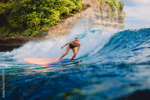 Surfer woman ride on wave surfing. Surfer and ocean wave in Bali
