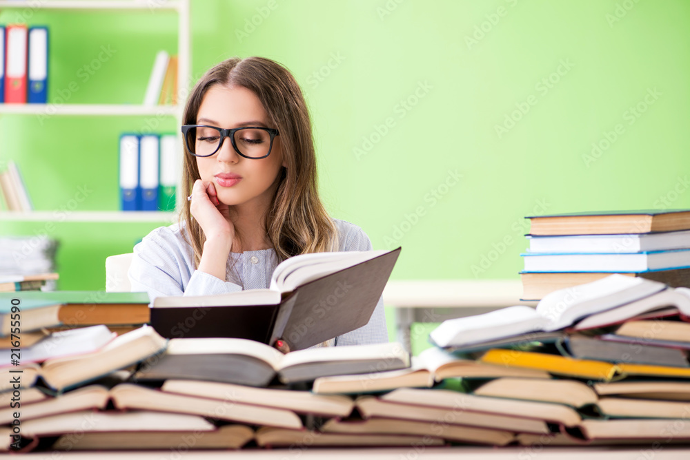 Young female student preparing for exams with many books Young female student preparing for exams with many books