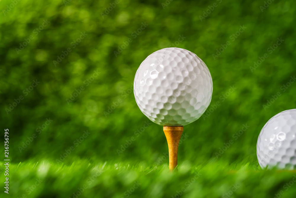 Golf ball with green grass background, on tee closeup. Golf ball with green grass background, on tee closeup.