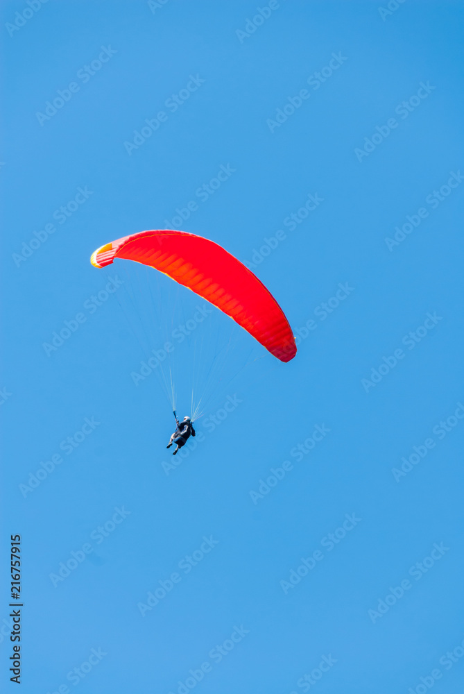 Hang glider soars through a pristine blue sky Hang glider soars through a pristine blue sky
