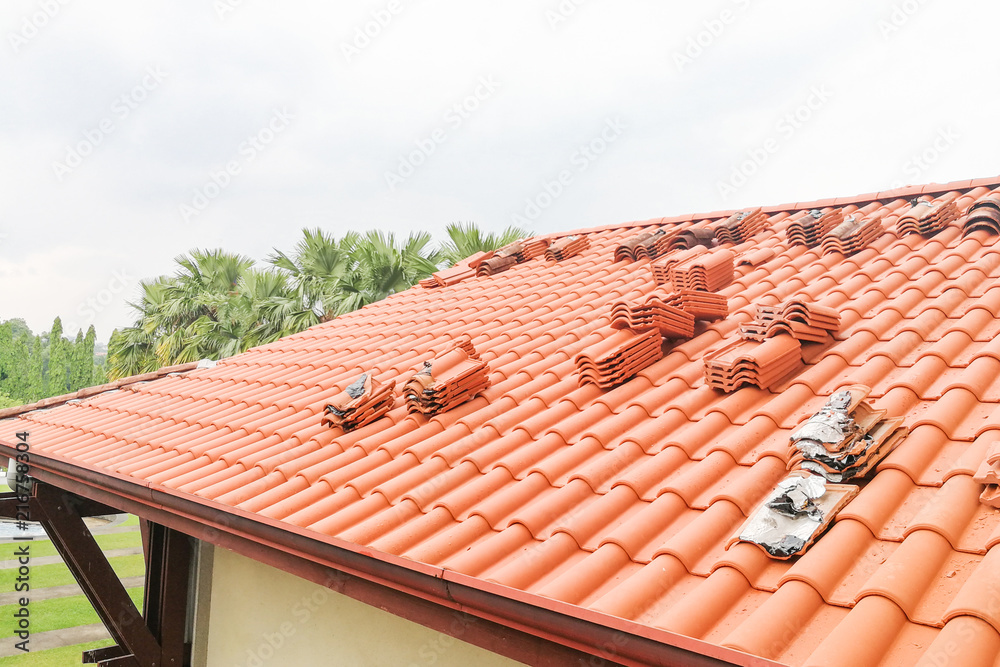Naklejka premium Old moldy roof tile being replaced with new tiles