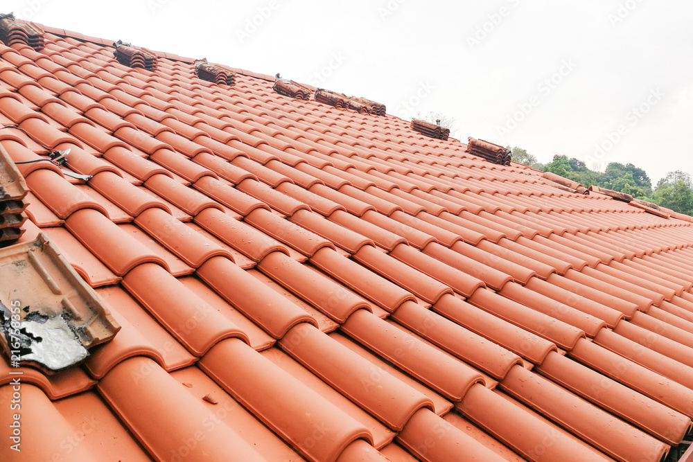 Old moldy roof tile being replaced with new tiles