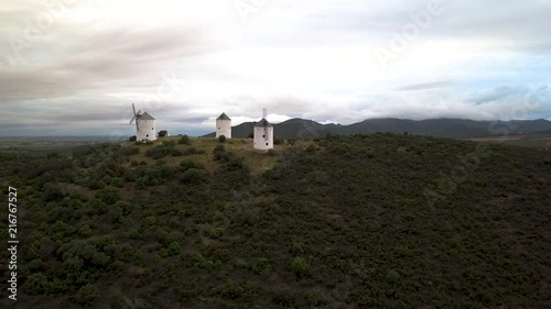 Sunset aerial footage of Spanish historical windmills on the hilltops of Puerto Lapice, Consuegra, Spain. photo