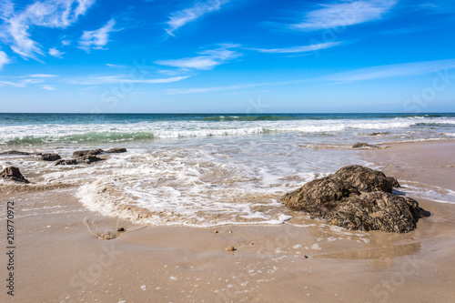 Waves breaking on beach with blue sky - Port Elizabeth, South Africa photo