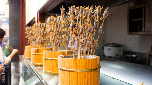 Living scorpions on a stick in a wooden basket photo