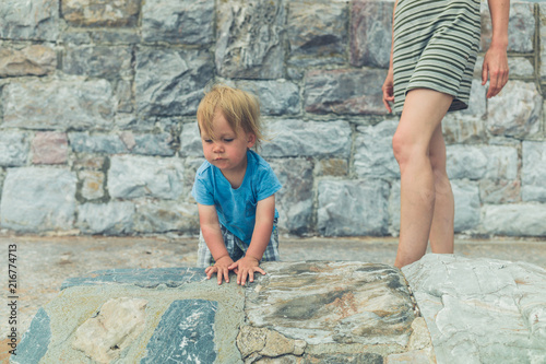 Mother and toddler by stone wall