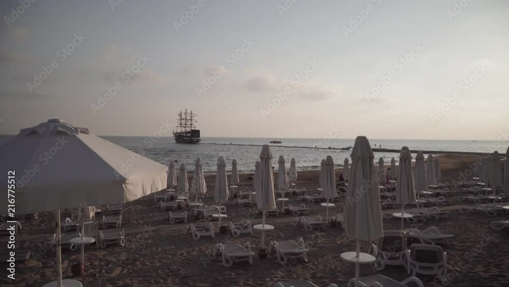 Sun Setting Across A Beach Filled With Sunbeds Sun Setting Across A Beach Filled With Sunbeds