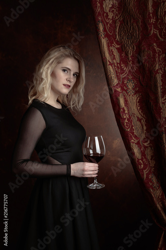 Portrait of beautiful young woman with red wine.
