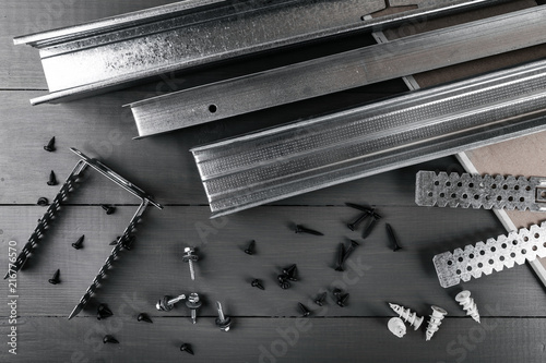 plasterboard profiles and fasteners on gray background. top view