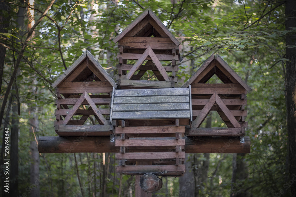 Multi-storey bird feeder in a dense forest. Like a fairy-tale hut on chicken legs Multi-storey bird feeder in a dense forest. Like a fairy-tale hut on chicken legs