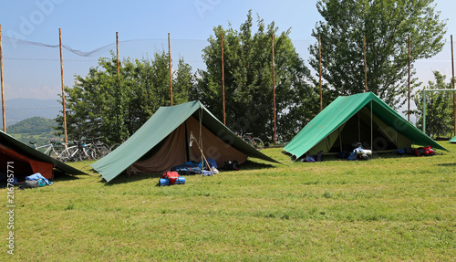 two green tents mounted by scouts in a meadow