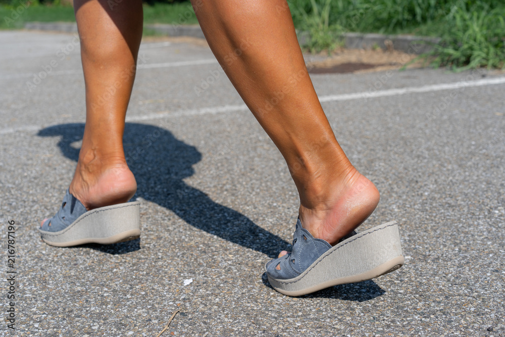 close up details legs wearing wedges sandal shoes, footwear in walking pose