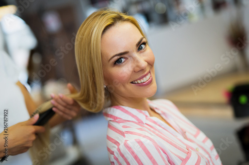 Hairdresser doing haircut for women in hairdressing salon.