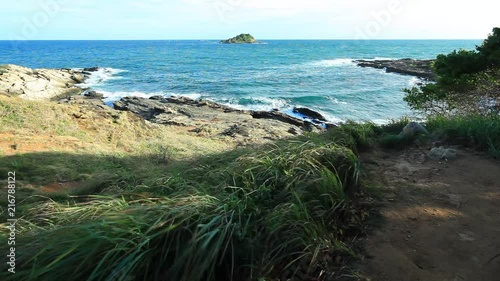 beautiful sea wave breaking on a stony tropical beach under the bright blue sky at summer day from tilt shift lens, high definition, Full HD, 1920x1080