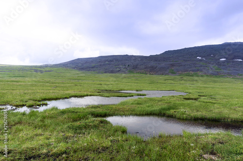 Raised bog with an open water lake in the mountain tundra