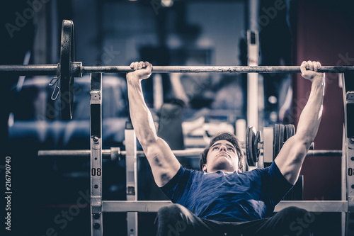 Man doing bench press in gym photo
