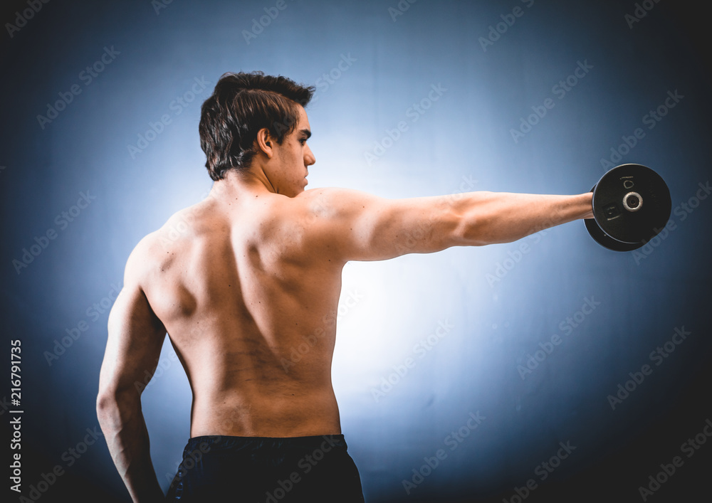 Sportsman with dumbbell in outstretched hand