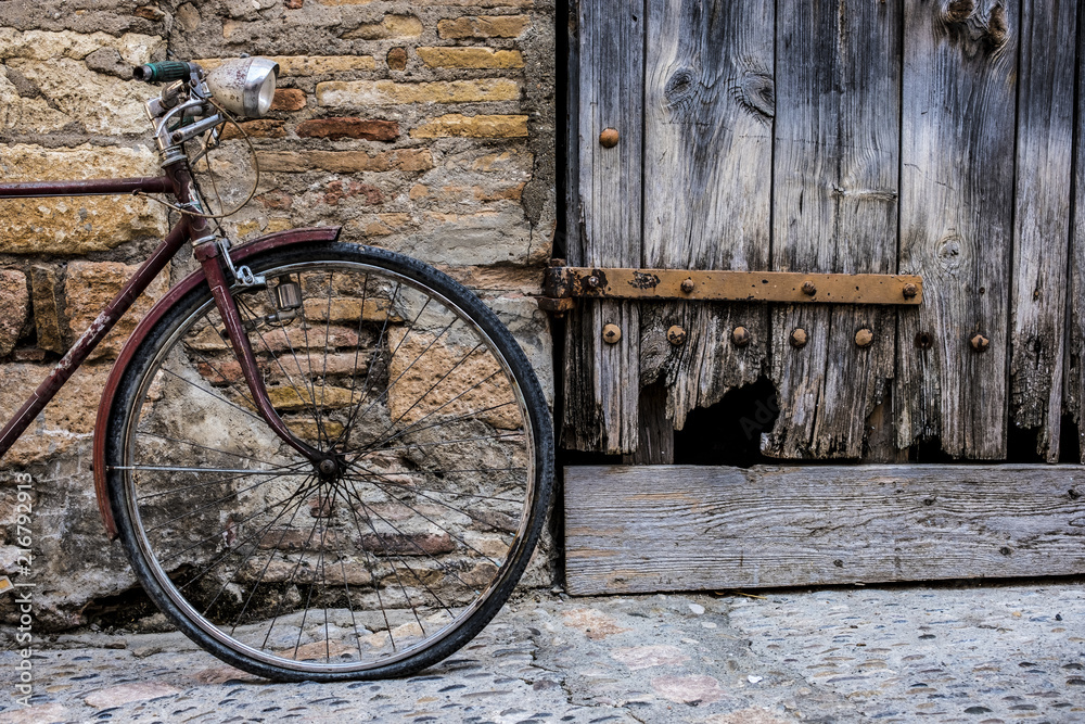 Old bicycle recharged on a rustic wall in a village street of medieval origin in the village of Alquezar in the province of Huesca in Aragon Spain Europe Old bicycle recharged on a rustic wall in a village street of medieval origin in the village of Alquezar in the province of Huesca in Aragon Spain Europe