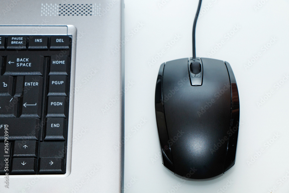 mouse and laptop on white table mouse and laptop on white table