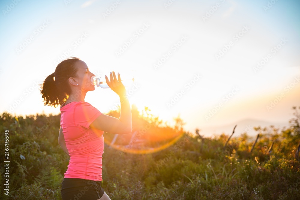 Woman drinking water from water bootle.