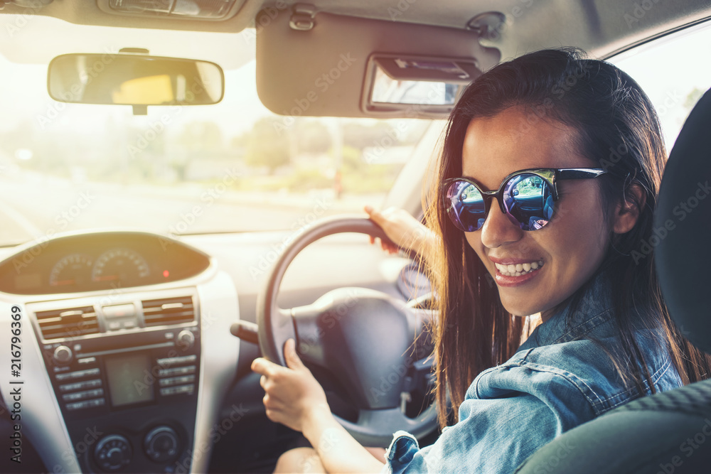 Naklejka premium beauty asian woman smile with sunglass driving car at sunset.