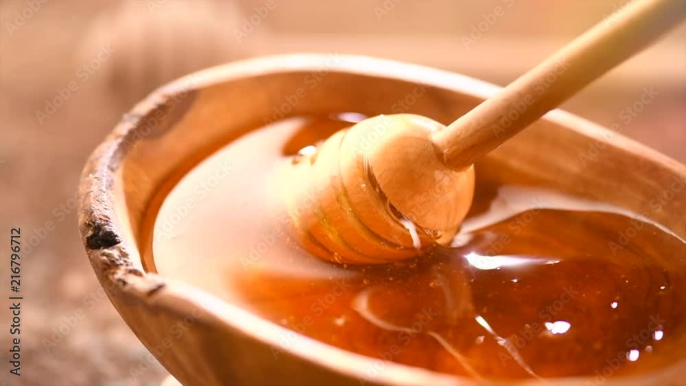 Honey dripping from honey dipper in wooden bowl. Healthy organic thick honey closeup. Slow motion. 3840X2160 4K UHD video footage Honey dripping from honey dipper in wooden bowl. Healthy organic thick honey closeup. Slow motion. 3840X2160 4K UHD video footage