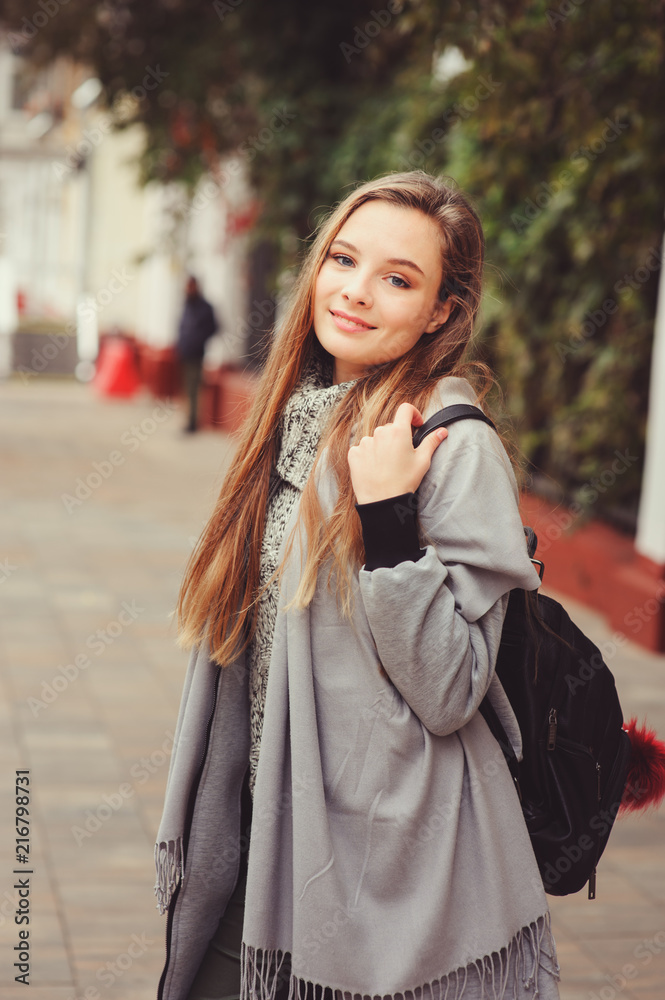 street style portrait of young beautiful happy girl walking in autumn city with trendy leather backpack street style portrait of young beautiful happy girl walking in autumn city with trendy leather backpack
