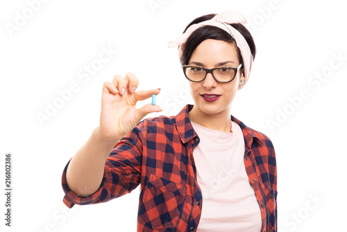 Young pretty pin-up girl showing blue pill.