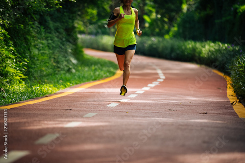 Healthy woman runner running on morning park road workout jogging © lzf