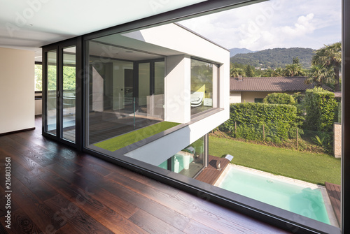 Large window in hallway of modern villa overlooking the private pool