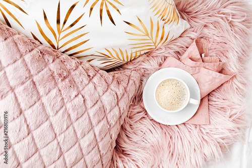 Bedding with a stylish pink pillows and cup of coffee. Copy space. Flat lay, top view