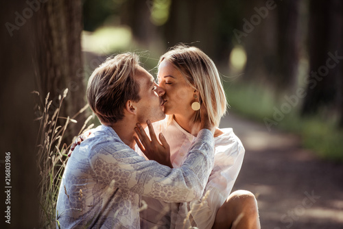 Frau und Mann im Park in romantischer Stimmung, küssend photo