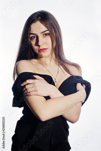 Close-up emotional portrait of a brunette girl in black jumpsuit on white background.