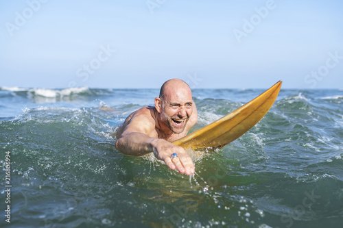 A senior man on a surfboard © Rawpixel.com